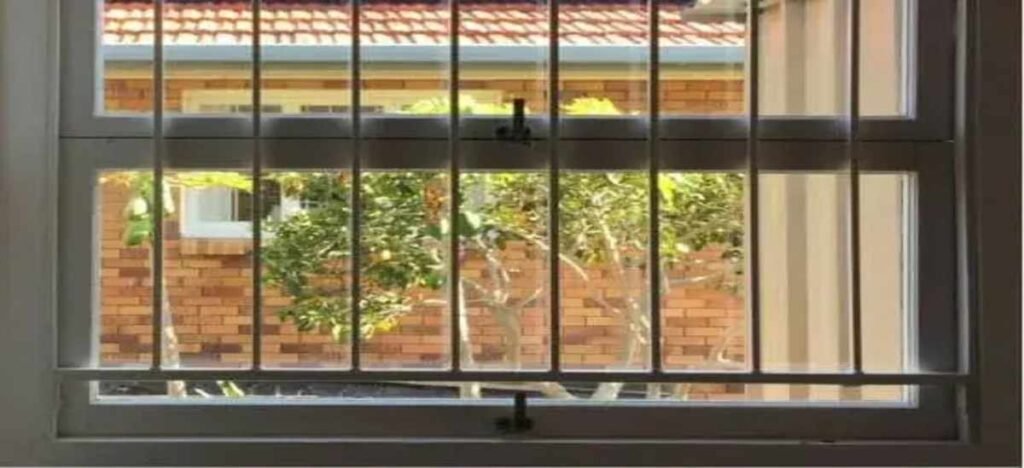Modern burglar bars on aluminium windows with quick-release mechanism